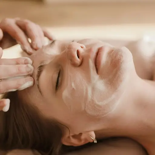 A close-up shot of a client receiving a deep cleansing facial at Bristol Beauty Line. The image shows a gentle cleansing process with foaming cleanser.